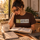 Camiseta feminina marrom JESUS glitter dourado sobre mesa, estilo lifestyle
